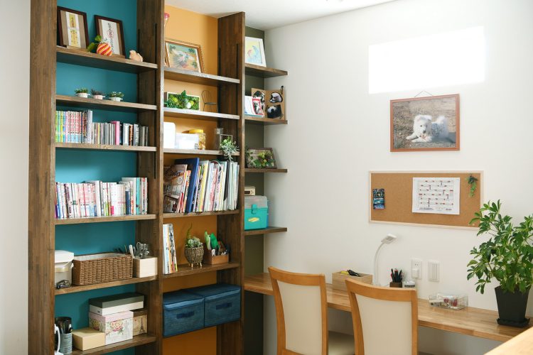 書斎コーナーは趣味のアクセサリーづくりなどに活用。本棚背面の青と黄の壁紙がお部屋のアクセントに